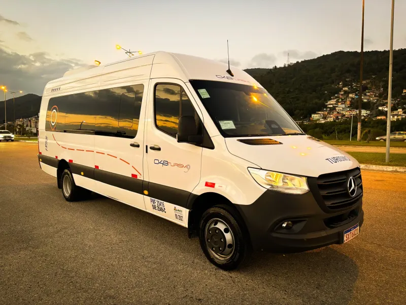 Van executiva branca da 048 Turismo ao entardecer